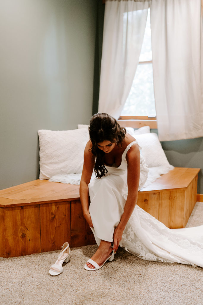 Bride puts on her shoes in her Airbnb before her Chicago wedding.