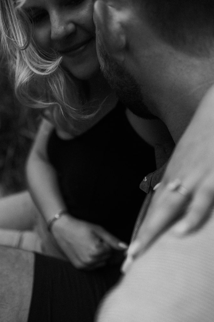 A close up black and white photo of a fiance smiling at her partner