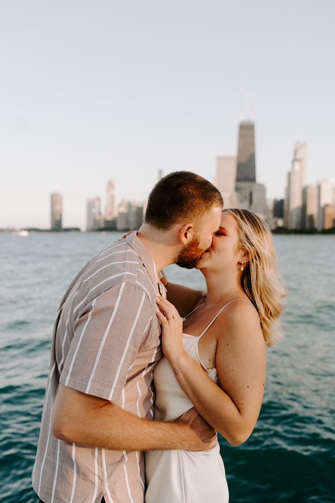 A couple kisses during their summer engagement session on North Avenue Beach in Chicago