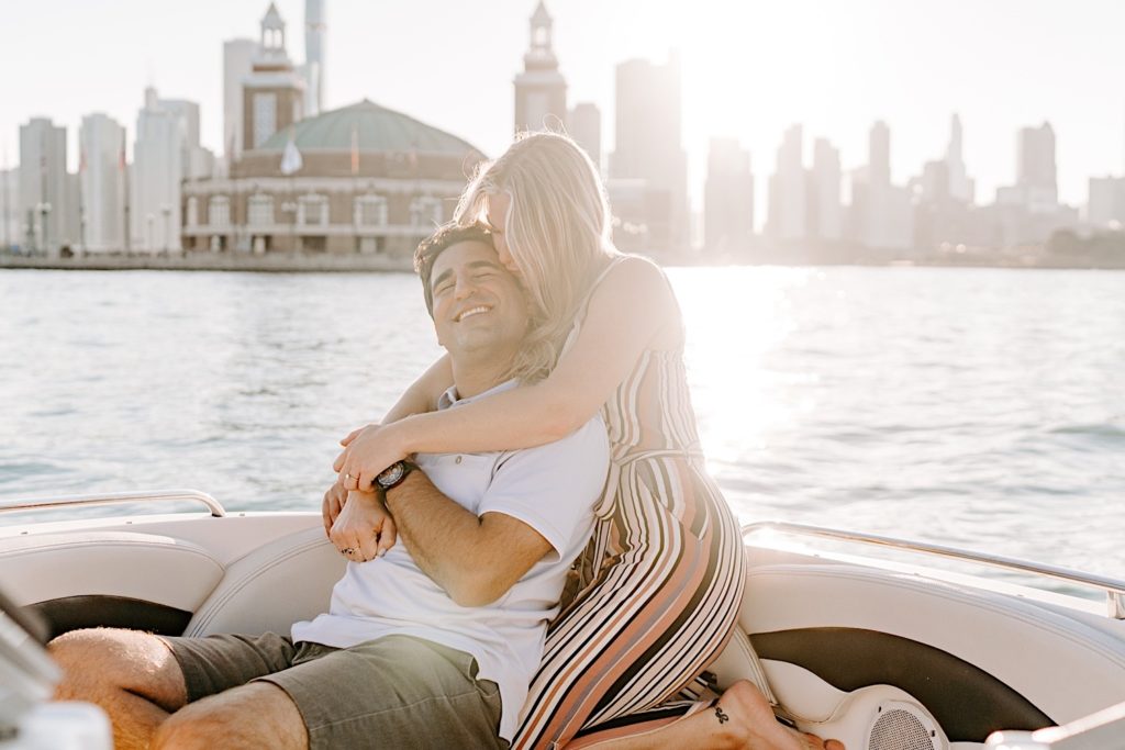 Fiancés snuggle in tight on a boat admiring the Chicago skyline
