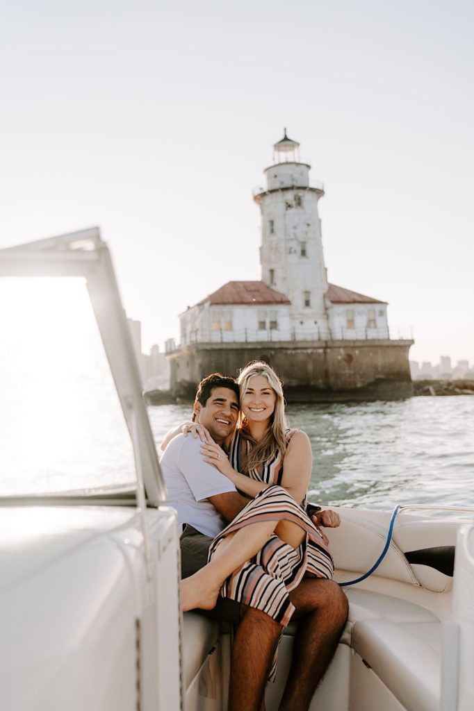 Fiancés hold each other tight on a boat admiring the Chicago skyline during their engagement session