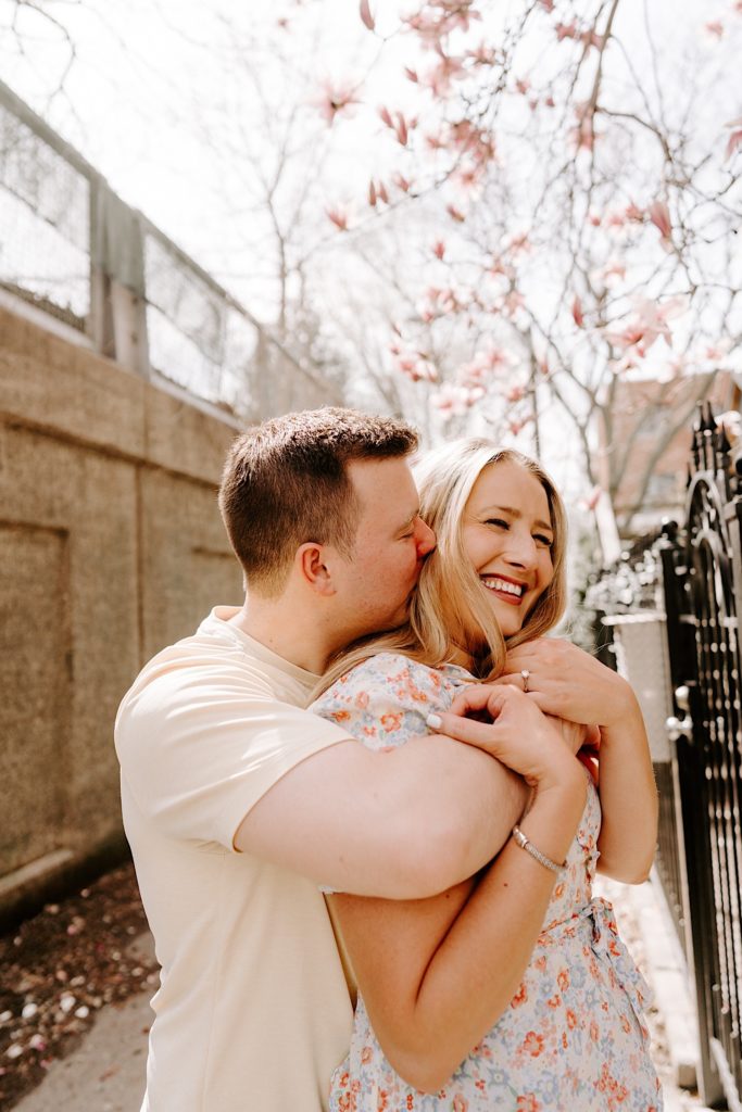 A fiancé holds his fiancée after proposing in a Chicago neighborhood in the spring.