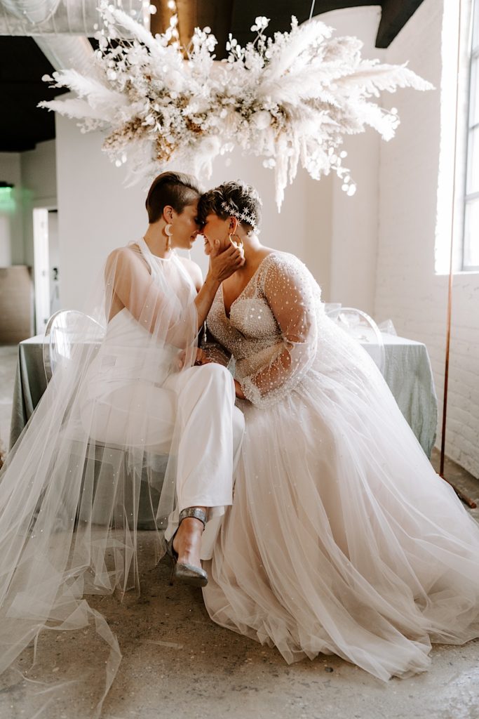 LGBTQ couples with celestial themed wedding attire take pictures in their wedding venue in Elgin Illinois.