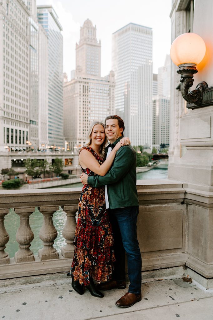  fiancé's standing next to the tribune tower on Michigan Avenue with a view of the Chicago River behind them