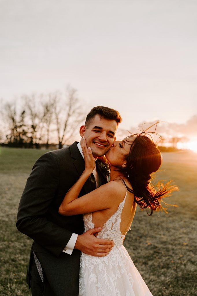 A bride kisses her groom during sunset on an Illinois farm on their wedding day.