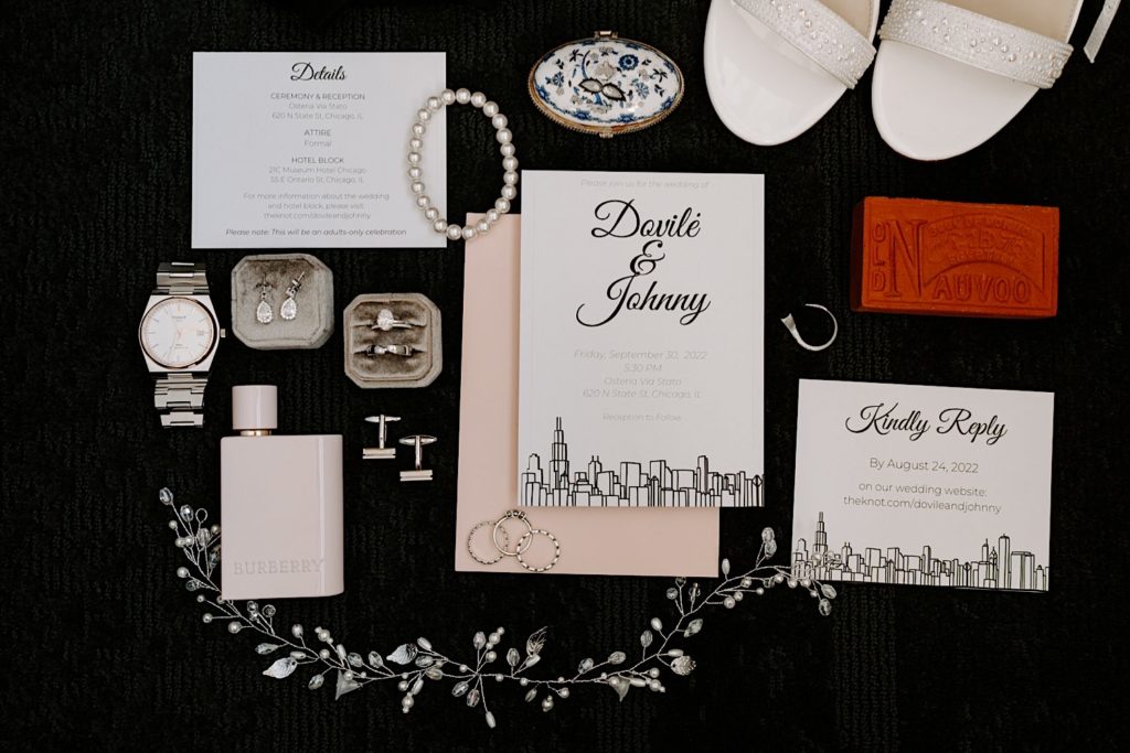 A pink and navy themed wedding day flat lay with crystal and pearl details.