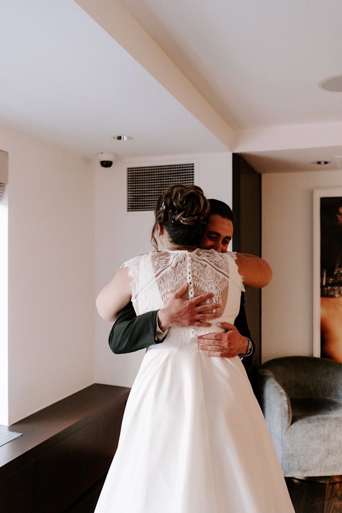 A bride and groom embrace the morning of their wedding.