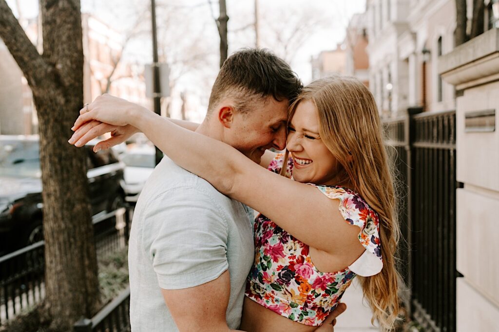 A couple embrace and smile during their photo session in Lincoln Park Chicago in the spring