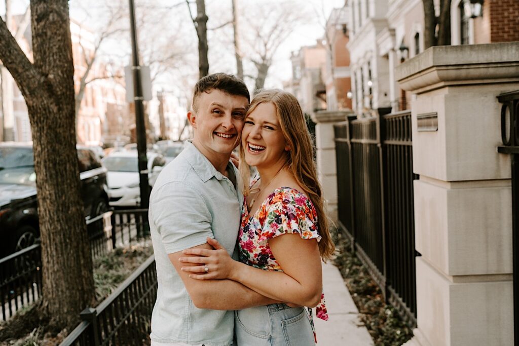 A couple embrace and smile at the camera during their couples session in Lincoln Park Chicago