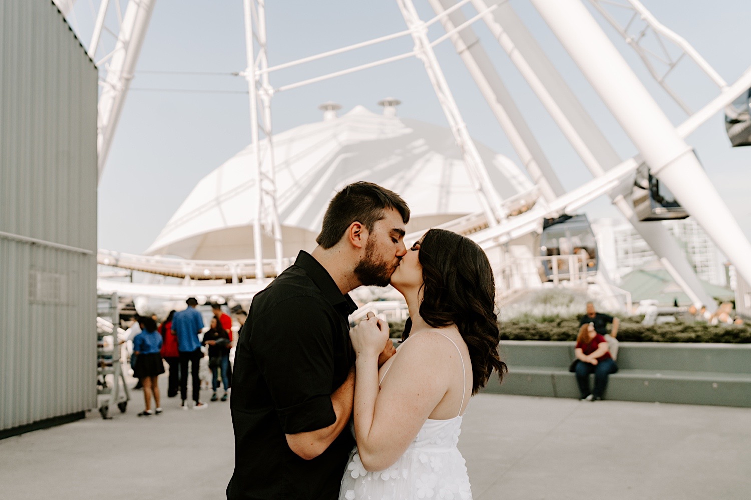 A couple kiss underneath the Ferris Wheel at Navy Pier in Chicago during their engagement session