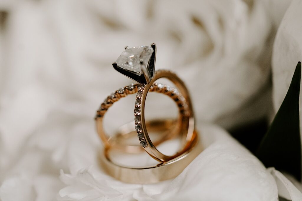 Detail photo of wedding rings set up inside of an engagement ring and standing on their own