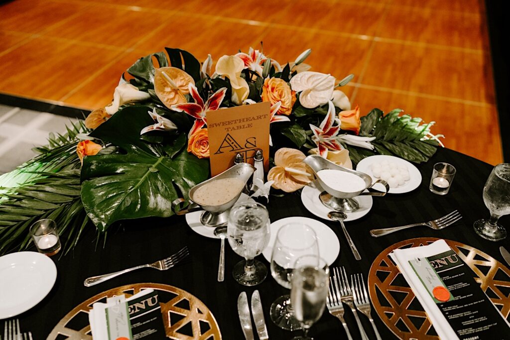 A table set up and decorated for a wedding reception with a sign that reads "Sweetheart Table" on it