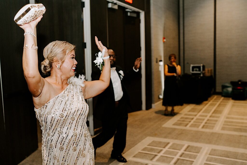 The mother and father of the bride celebrate as they enter the wedding reception of their daughter at the Hyatt Regency together