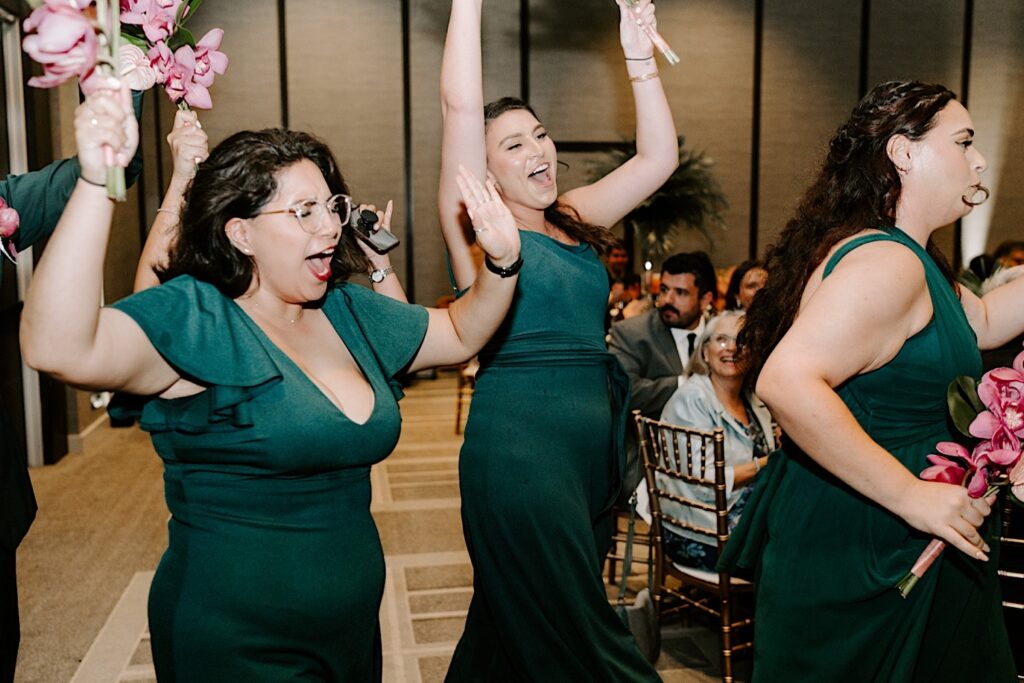 Bridesmaids celebrate as they enter an indoor wedding reception at the Hyatt Regency