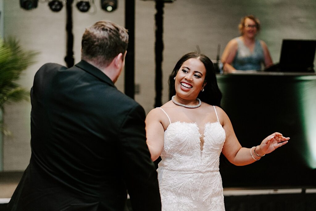 A bride smiles while dancing with the groom during their indoor wedding reception at the Hyatt Regency