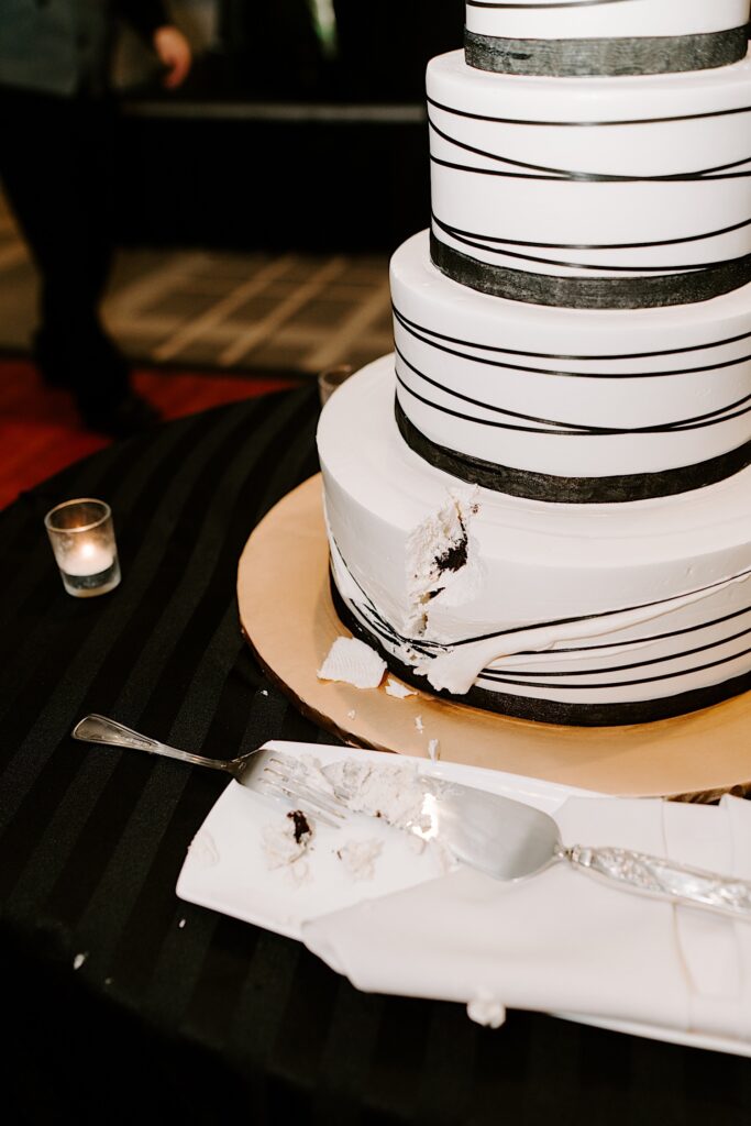 Photo of a wedding cake with a chunk cut out of it by the bride and groom