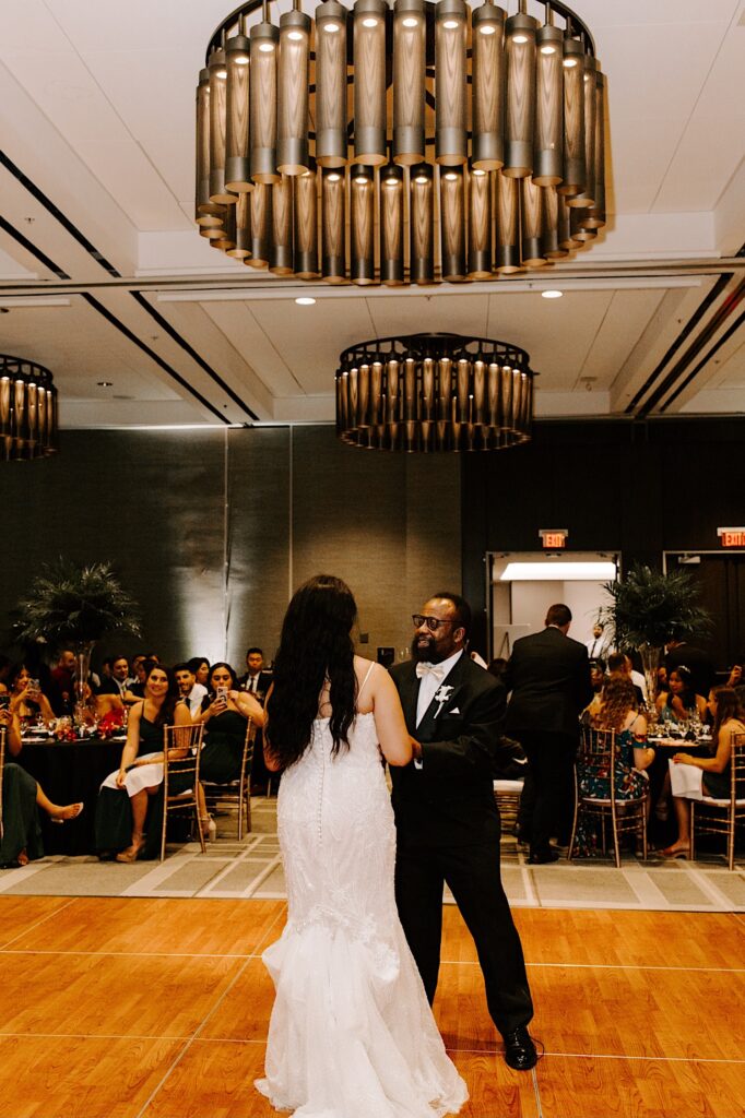 A bride dances with her father during her indoor wedding reception