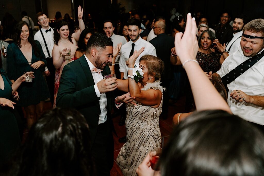 Guests of an indoor wedding reception at the Hyatt Regency celebrate and dance together