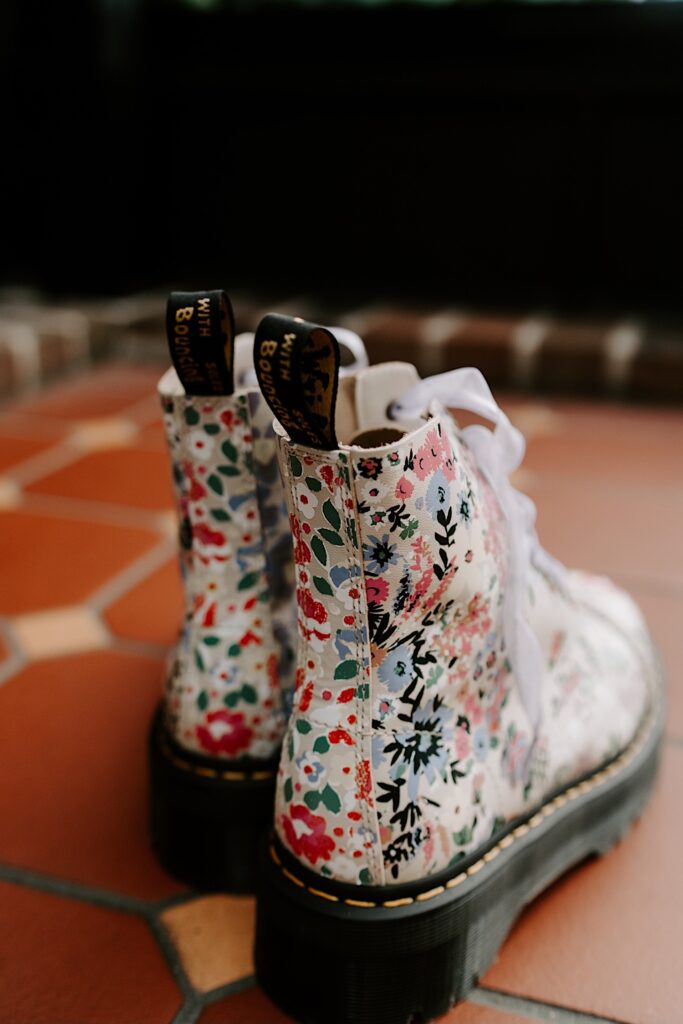 Close up photo of floral boots resting on a tile floor