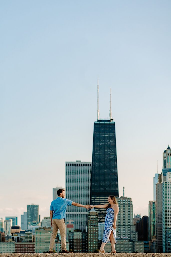 A man and woman dance together with the Chicago skyline in the background