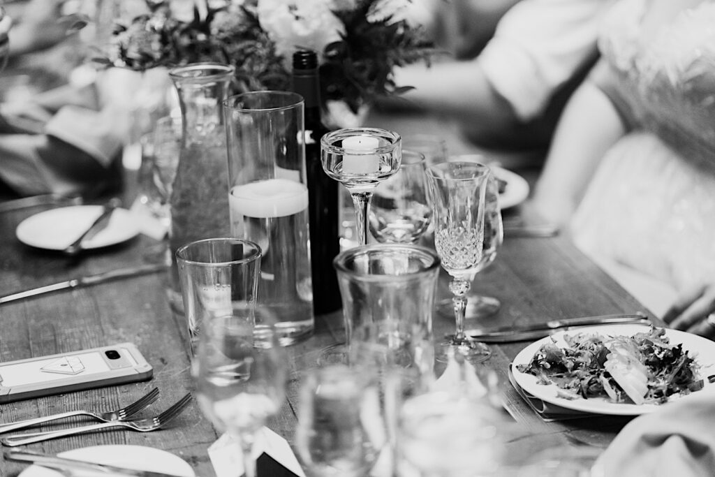 Black and white photo of glassware and other décor on a table during a wedding reception at The Atrium in Milwaukee