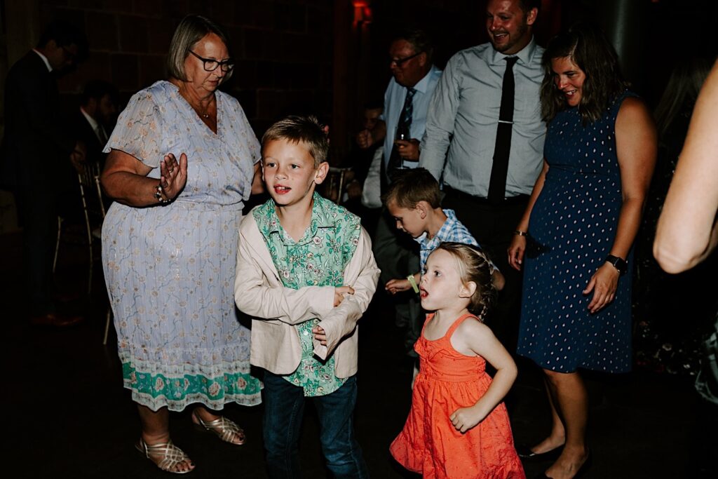 Children dance in a circle of adults during an indoor wedding reception at The Atrium in Milwaukee