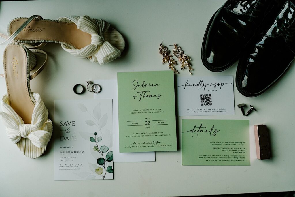 A wedding day flatlay consisting of rings, invites, earrings, and shoes