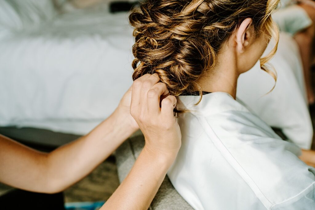 Close up photo of a bride having her hair worked on as she gets ready for her wedding day