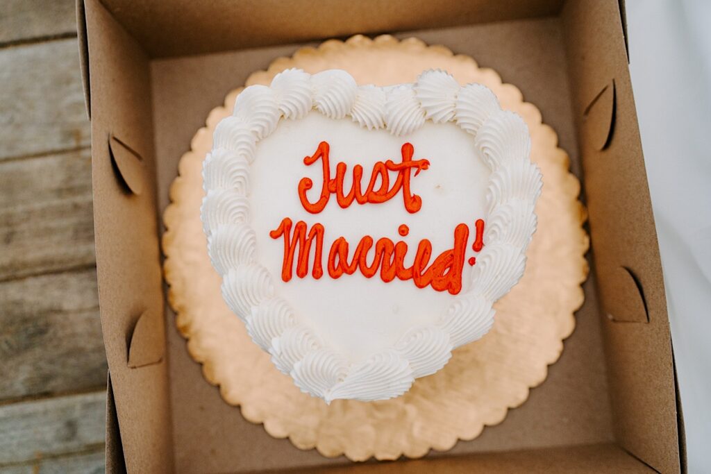 A white heart cake reads "Just Married!" in red frosting