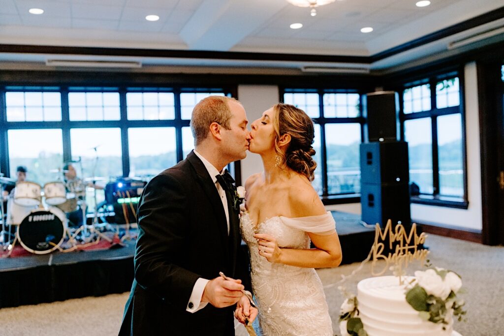 A bride licks frosting off of the nose of the groom during their indoor wedding reception at the Makray Golf Club in the Chicagoland area