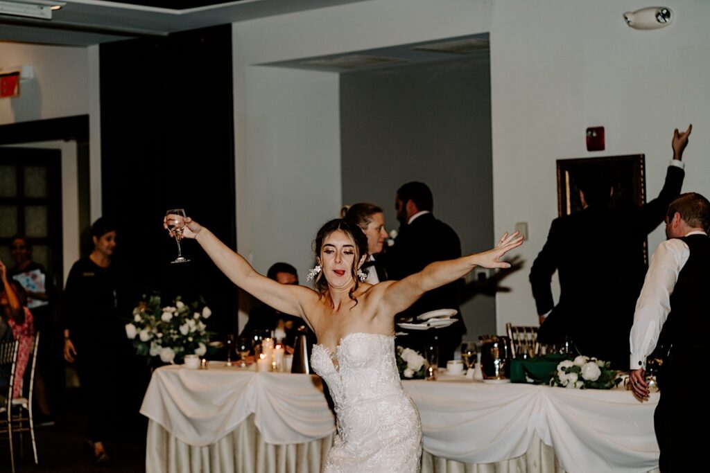 A bride dances with guests around her during an indoor wedding reception at the Makray Golf Club in the Chicagoland area