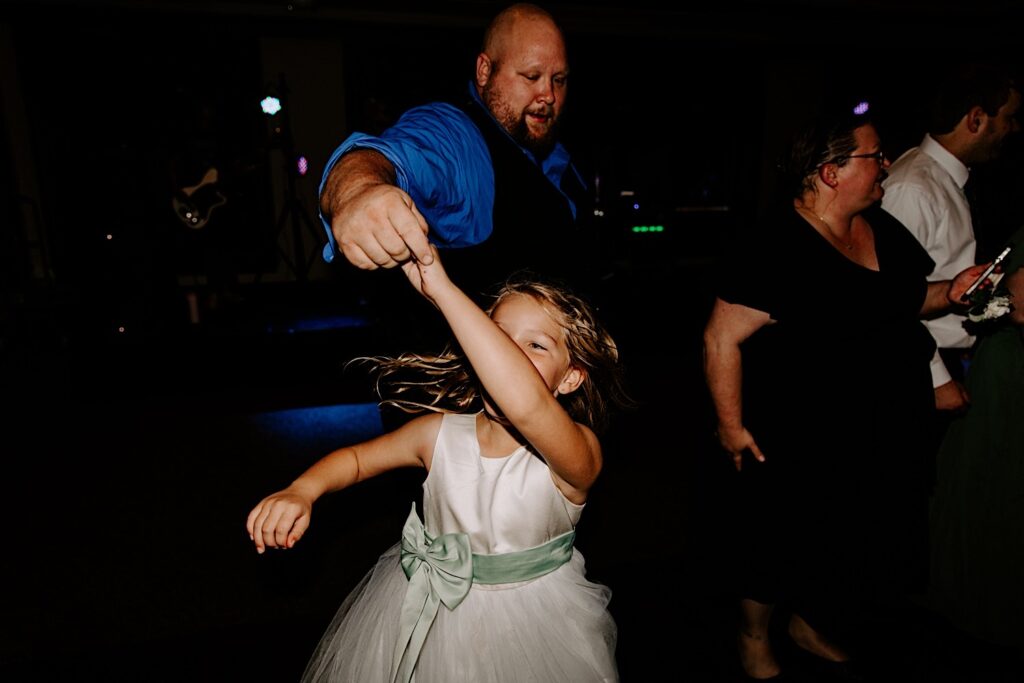 A flower girl dances with her father during an indoor wedding reception at the Makray Golf Club in the Chicagoland area