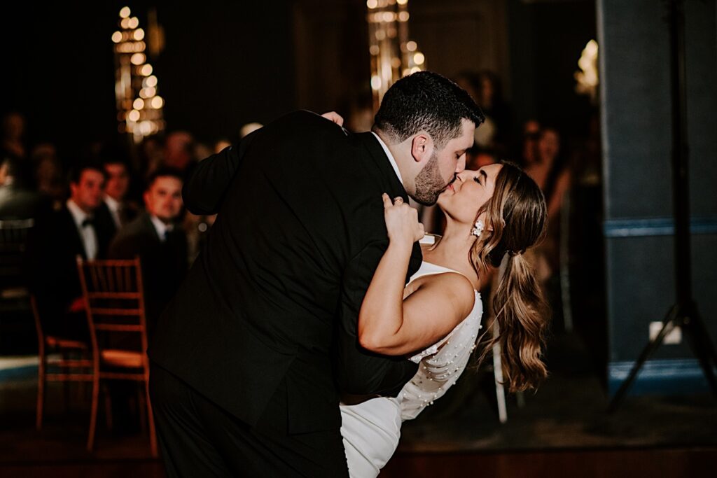 A bride and groom kiss one another during their first dance at their reception inside the Voco Hotel in Chicago