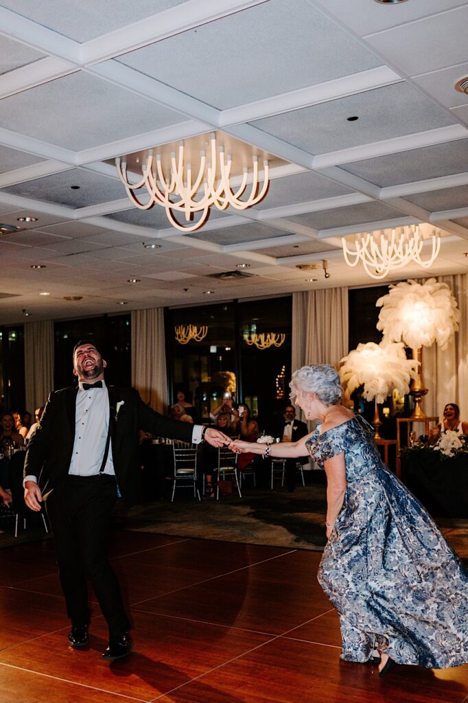 A groom and his mother burst into laughter while they dance during the reception inside the Voco Hotel in Chicago