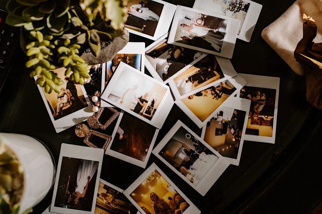 Polaroid photos of a wedding day lay on a table next to one another