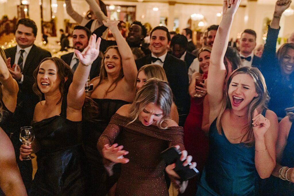 Guests of an indoor wedding reception at The Haley Mansion all cheer and celebrate together