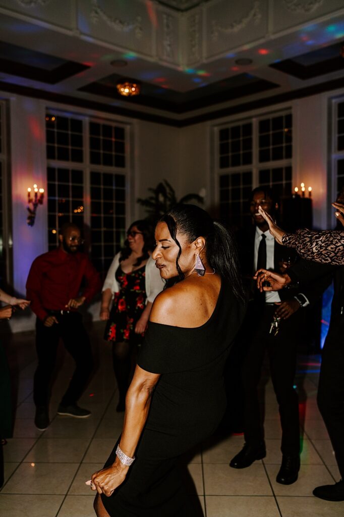 The mother of the groom dances on the dance floor with other guests of her son's wedding