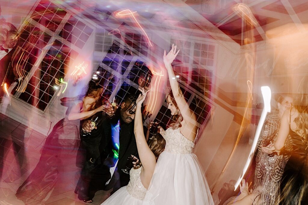A bride and groom dance together with guests of their indoor wedding reception at The Haley Mansion