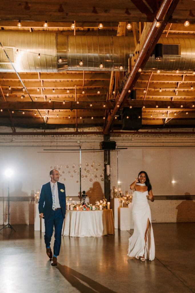 Bride in a strapless gown makes her way to the dance floor with her husband beside her in a blue suit in the reception room of the Walden Chicago. 