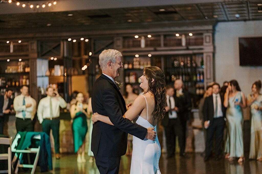 A bride shares a first dance with her dad at an industrial style wedding venue at CD&ME in Frankfort Illinois.